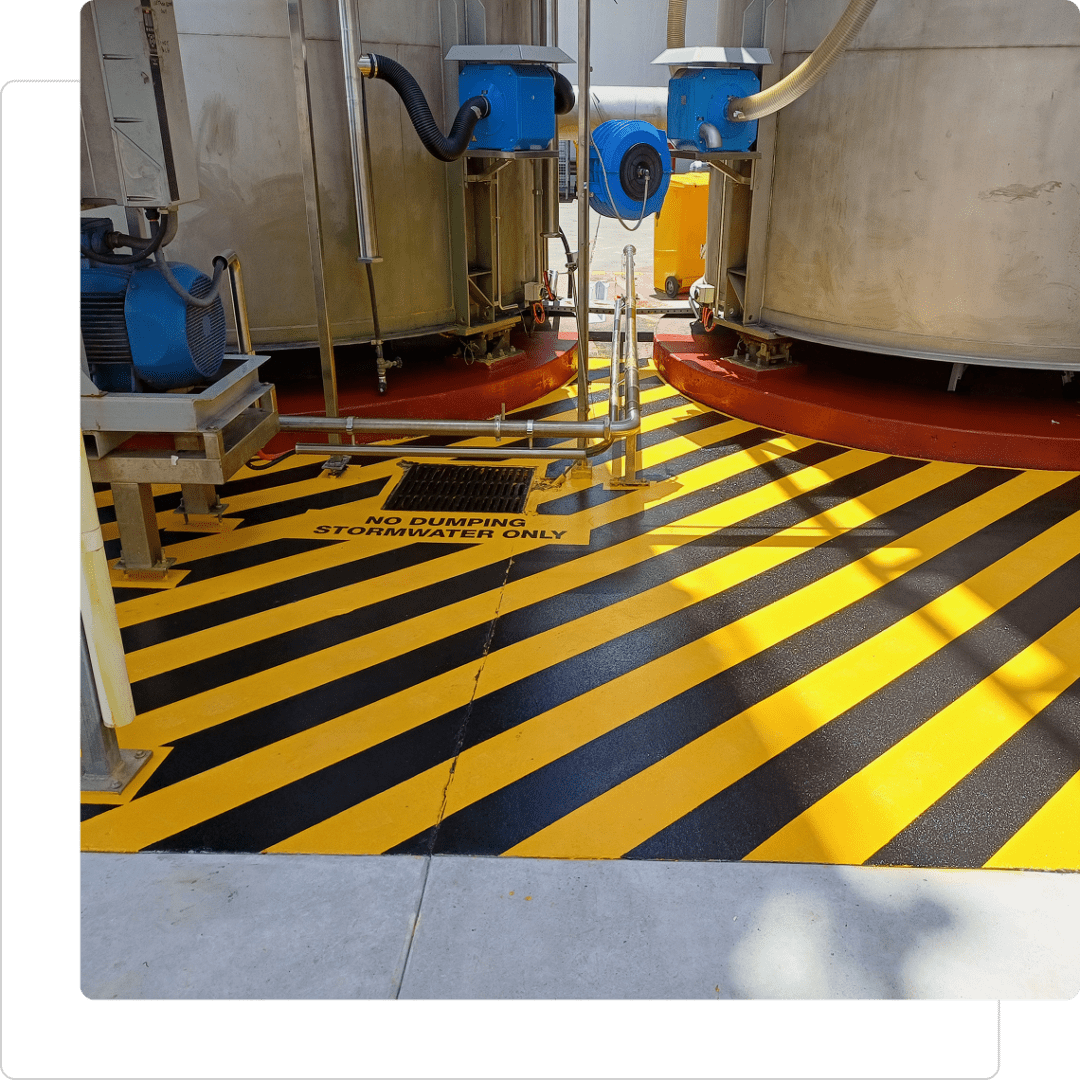 Industrial tanks with striped caution floor.
